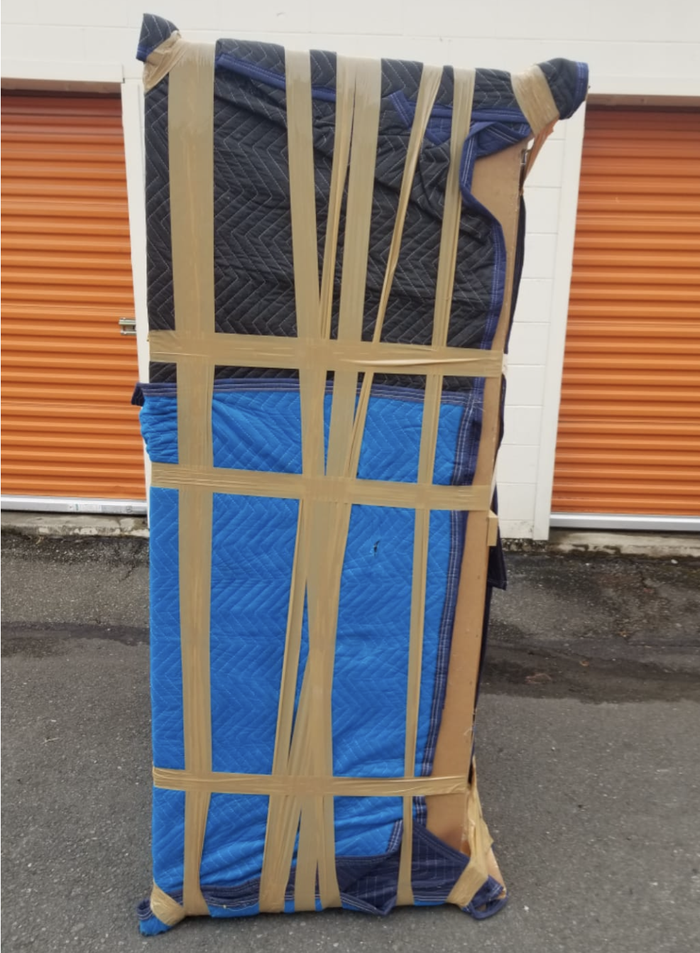 Large cabinet fully padded and taped outside a storage unit